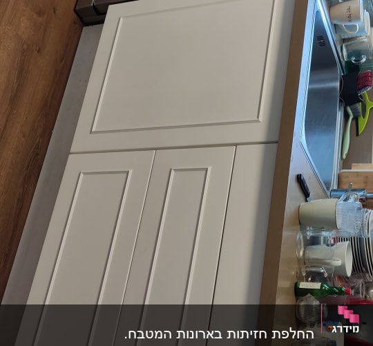 ארונות מטבח לבנים, כיור נירוסטה, כלים על השיש
